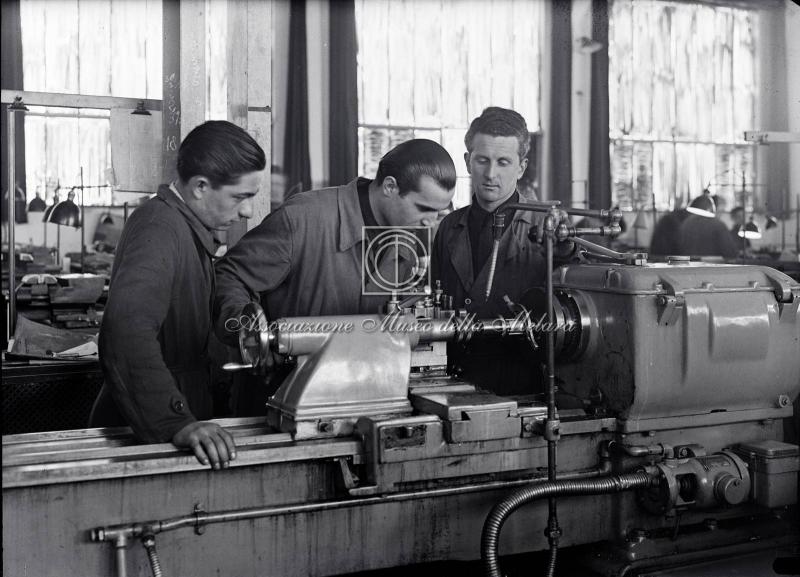 Operai al lavoro su macchinario industriale